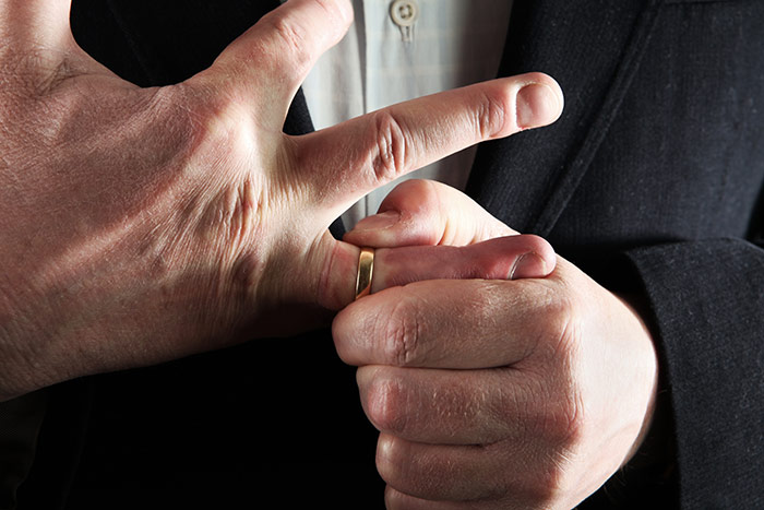 man removing wedding band